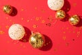 Christmas white and gold decorations, mirror disco balls, star sparkles over red background. Flat lay, top view. Minimal New year Royalty Free Stock Photo