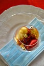 Christmas white plate, medical protective mask. Covid. A glass of alcohol with toys to decorate for the winter holidays. Backgroun Royalty Free Stock Photo