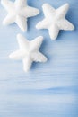 Christmas white snow stars on light blue wood background with space for text. Royalty Free Stock Photo