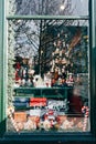 Christmas window decoration with figurines and toys with street reflection in glass.