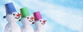 Christmas winter banner - view of a family of snowmen on a background of snow in a winter forest