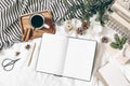 Christmas, winter composition. Blank greeting card, open diary, sketch book mock-up scene. Cup of coffee, old book, pine