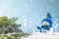 Christmas or winter composition. Little knitted snowmans on soft snow on blue background. Christmas, winter, new year concept