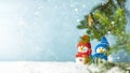 Christmas or winter composition. Little knitted snowmans on soft snow on blue background. Christmas, winter, new year concept