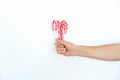 Christmas, winter concept. Holidays, sweets, treats. Man hands holding traditional striped candy cane in shape of bouquet. Male ha