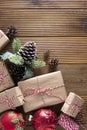 Christmas and winter holidays background. Cchristmas gift box with pine cones, fir brances, on brown wood table with copy space.