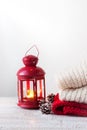 Christmas or winter home concept with lantern, fir cones, snow and warm wear