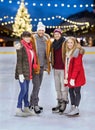 Happy friends at christmas skating rink Royalty Free Stock Photo