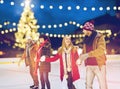 Happy friends at christmas skating rink Royalty Free Stock Photo