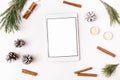 Christmas winter new year composition. Digital tablet mock up with Fir tree branches pine cone cinnamon sticks candles