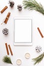 Christmas winter new year composition. Digital tablet mock up with Fir tree branches pine cone cinnamon sticks candles on