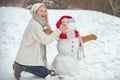 Christmas winter poeple. Winter background with snowflakes and snowman. Outdoor portrait of young pretty beautiful woman Royalty Free Stock Photo
