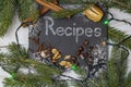 Christmas or winter recipes, word written on a black stone tile with white chalk, surrounded by fir branches