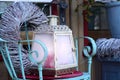 Christmas and winter still life with a romantic old lantern, which has frozen glazed panes, on a chair in front of a wooden door Royalty Free Stock Photo