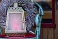 Christmas and winter still life with a romantic old lantern, which has frozen glazed panes, on a chair in front of a wooden door Royalty Free Stock Photo