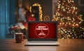 Christmas wishes on a laptop and Santa bringing gifts at home