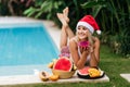 Christmas woman beautiful smiling in Santa`s hat with a tropical fruits Royalty Free Stock Photo