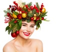 Christmas Woman Beauty Happy smiling. Fashion Model with Fir Tree Wreath Hairstyle decorated with Balls and Gifts. Women Face Royalty Free Stock Photo