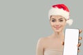 Christmas woman. Cheerful Santa model showing smartphone with empty white screen display, Mockup banner Royalty Free Stock Photo