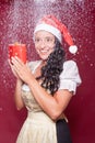 Christmas woman in dirndl with packet during snowfall Royalty Free Stock Photo