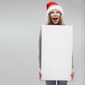 Christmas woman hold big white card. Santa hat. Royalty Free Stock Photo