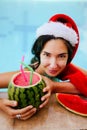 Christmas woman in Santa& x27;s hat with watermelon cocktail in swimming pool Royalty Free Stock Photo