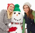 Christmas, women and snowman with snow and holiday celebration, xmas portrait and happiness in winter. Friends, happy Royalty Free Stock Photo