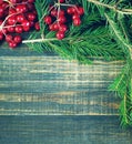 Christmas wooden background with branches of a fir-tree and red berries Royalty Free Stock Photo