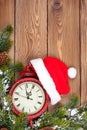 Christmas wooden background with clock, fir tree and santa hat Royalty Free Stock Photo