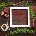 Christmas wooden background. Fir branches and cones with white frame for copyspace. Royalty Free Stock Photo