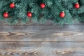 Christmas wooden background with fir branches and red festive decorations. New Year frame. Copy space, top view, flat lay Royalty Free Stock Photo