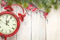 Christmas wooden background with fir tree and antique alarm clock