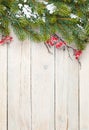 Christmas wooden background with fir tree and holly berry