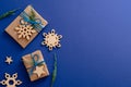 Christmas wooden decorations and gift boxes on dark blue background with copy space. Xmas card mockup, festive social media banner