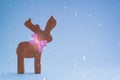 Christmas wooden deer on a blue background. Postcard with snowflakes effect