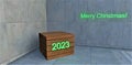 Christmas wooden stand for gift in concrete room. Green glowing inscription 2023. 3d rendering