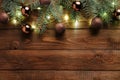 Christmas wooden table with fir tree branches, lights and brown balls decoration. Christmas holiday celebration, winter, New Year Royalty Free Stock Photo