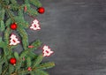 Christmas wooden toys in the form of a Christmas tree of white and red colors, red balls and fir branches on a black background Royalty Free Stock Photo