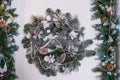 Christmas wreath with baubles, cones and evergreen boughs on a white door.Wreath decoration at door for Christmas Royalty Free Stock Photo