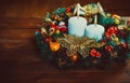 Christmas wreath with burning candles on wooden table. Royalty Free Stock Photo