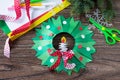 Christmas wreath with a candle on a written wooden table. Made by own hands.