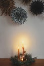 Christmas wreath with candles on wooden table and paper stars. Holiday advent, scandinavian hygge Royalty Free Stock Photo