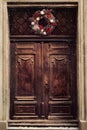 Christmas Wreath Decoration at Door for Winter Holiday. Antique Brown Wooden House Entrance Decorated for Xmas. Vintage Style Royalty Free Stock Photo