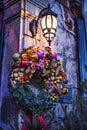 Christmas wreath on door under retro vintage lantern on Christmas eve in beautiful fairy tale lighting in european old town city. Royalty Free Stock Photo