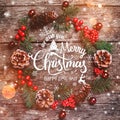 Christmas wreath of Fir branches, cones, red decorations on dark wooden background. Royalty Free Stock Photo