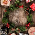 Christmas wreath of Fir branches, many Christmas gift boxes with red decoration and pine cones on wooden background with snowflake Royalty Free Stock Photo