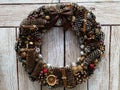 Christmas wreath of fir cones, nuts, berries, brown on a beige plank background