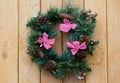 Christmas wreath with fir cones on wooden wall