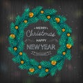 Christmas wreath with gold balls decorations, calligraphic logo on black wooden background. Royalty Free Stock Photo