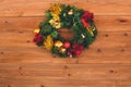 Christmas wreath handmade on a wooden background. Festive lights of garland. New Year`s interior decoration. Royalty Free Stock Photo